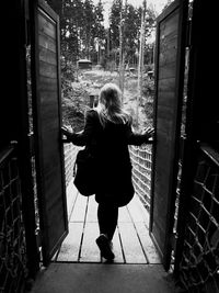 Rear view of woman standing by railing