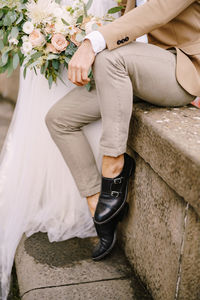 Low section of woman sitting on sidewalk