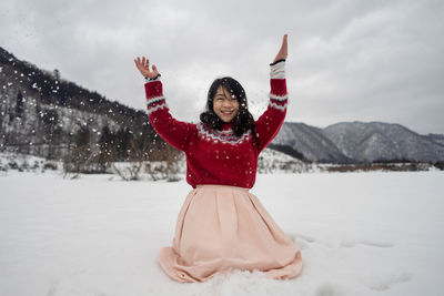 Portrait of woman playing in snow