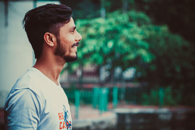 Portrait of young man looking away outdoors