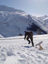 Rear view of a man walking on snow covered landscape