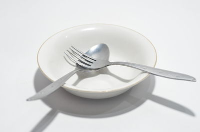 High angle view of empty plate on table against white background