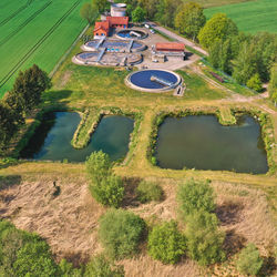 Aerial view of a sewage treatment plant with downstream septic tanks at the edge of a village 