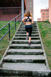 Rear view of woman running on staircase