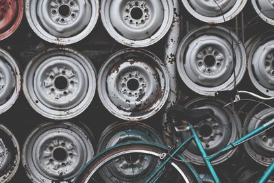 Bicycle parked against wheel rims on wall