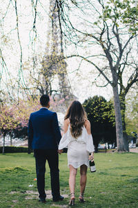 Rear view of friends walking in park