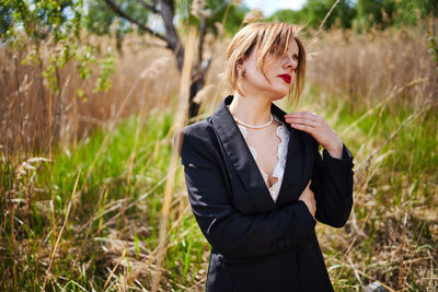 Portrait of young woman standing on field