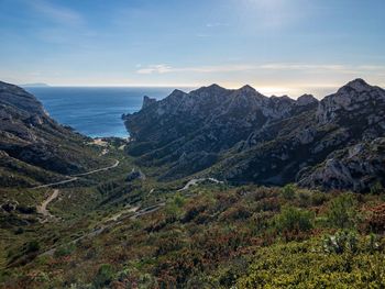 Scenic view of sea and mountains against sky