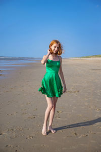 Full length of young woman standing at beach