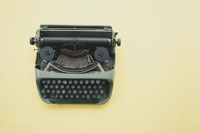Close-up of typewriter against yellow background