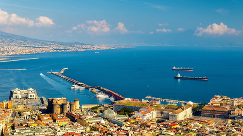 High angle view of buildings by sea against sky