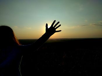 Rear view of silhouette woman at sunset