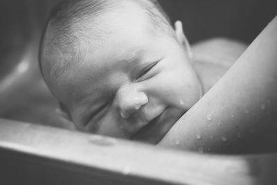 Cropped image of mother bathing baby at home