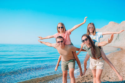 People enjoying at beach against sky