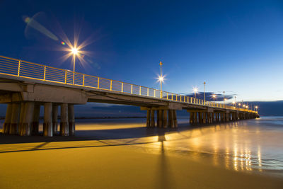 View of bridge over sea at night