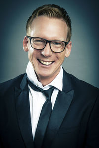 Portrait of man wearing eyeglasses against black background