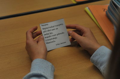 Midsection of woman holding text on table