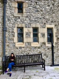 Portrait of woman standing against brick wall