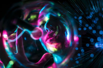 Close-up of woman with light painting at night