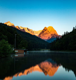 Scenic view of lake and mountains against clear sky