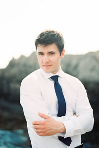 Portrait of young man standing against sky