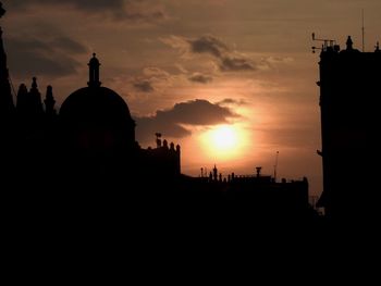 Silhouette buildings against sky during sunset