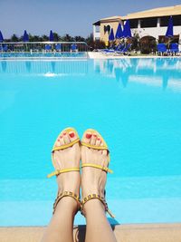 Low section of woman relaxing at poolside