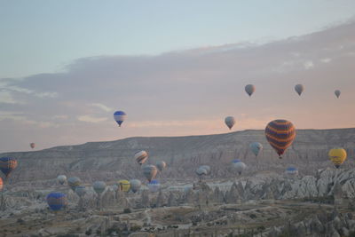 Hot air balloons flying over landscape against sky