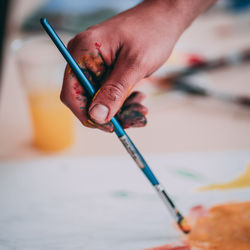 Cropped hand of person painting on table