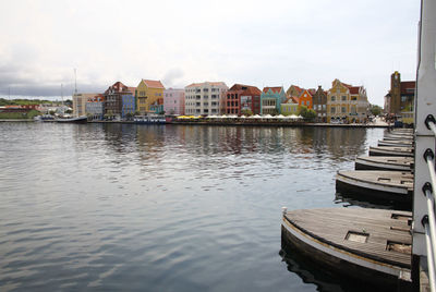 Boats moored in city against sky