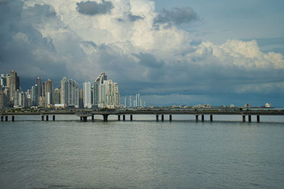 Pier over sea against buildings in city