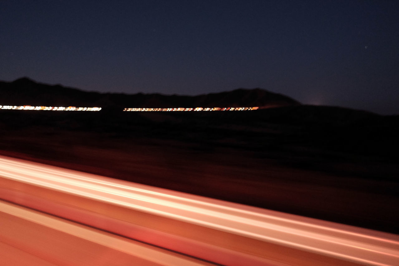 LIGHT TRAILS AGAINST SEA AT NIGHT