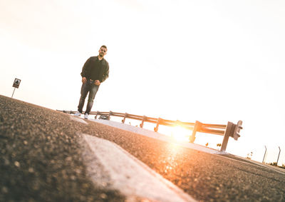 Portrait of man standing on road against sky