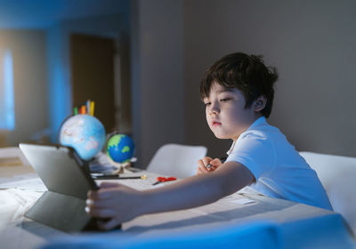 Boy sitting on table at home