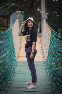 Portrait of young woman walking on footbridge