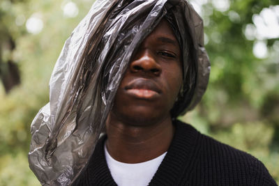 Young african man with plastic over head. plastic pollution concept
