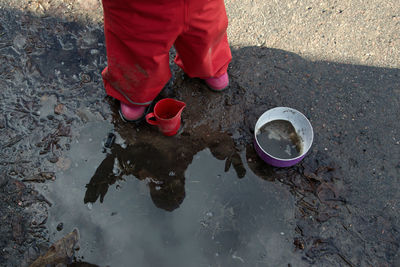 Low section of man standing in puddle