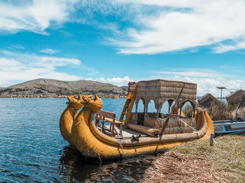 Abandoned boat on beach against sky