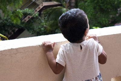 Rear view of boy standing outdoors