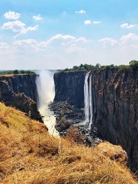 Scenic view of waterfall against sky