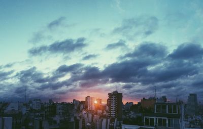 View of cityscape against cloudy sky