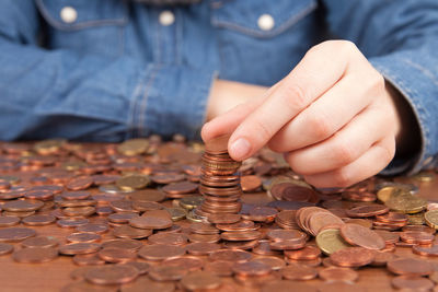 Midsection of woman stacking coins