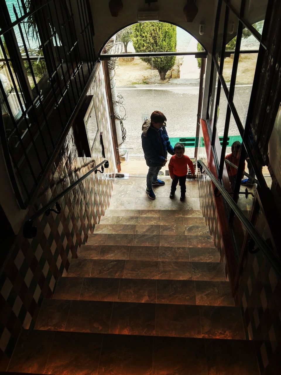 REAR VIEW OF PEOPLE WALKING IN STAIRCASE