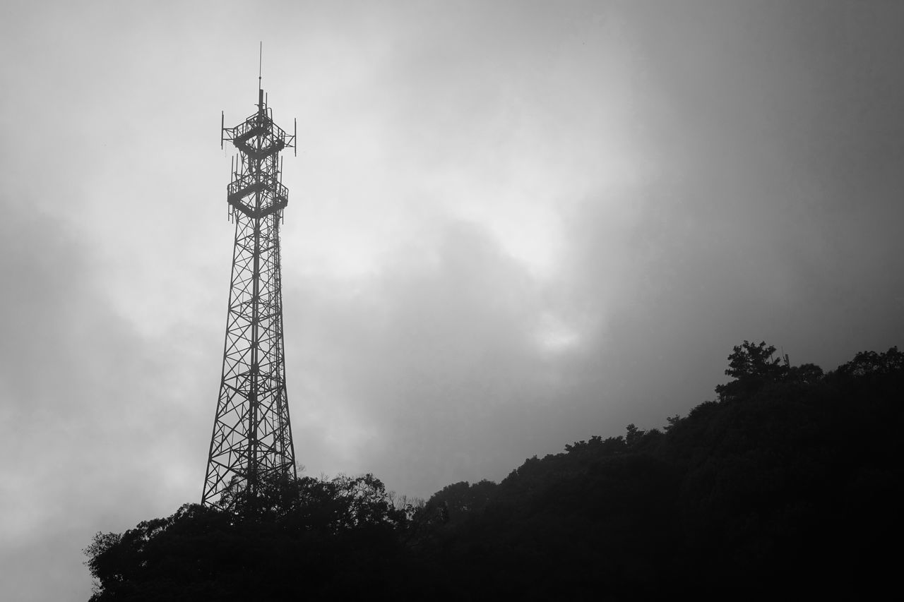 low angle view, sky, tree, silhouette, cloud - sky, built structure, cloudy, tall - high, architecture, technology, dusk, outdoors, nature, tower, weather, fuel and power generation, cloud, day, no people, overcast