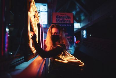 Woman in illuminated traditional clothing sign at night