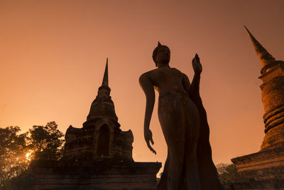 Statue of historic building against sky during sunset