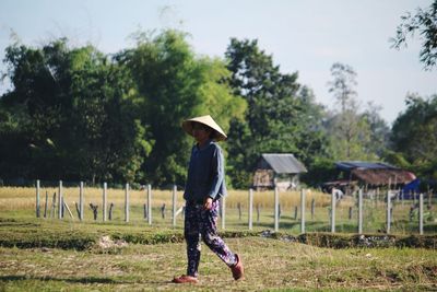 Full length rear view of man walking on field