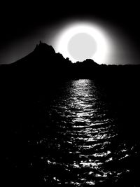Silhouette mountain by sea against sky