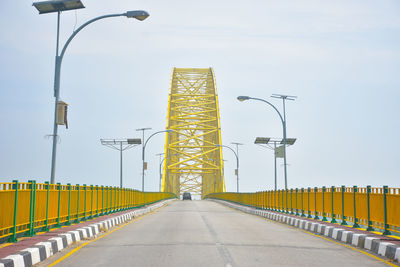 Street lights on bridge against sky