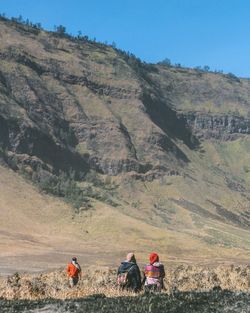 Rear view of people walking on land